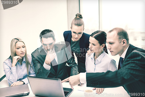 Image of business team with laptop having discussion