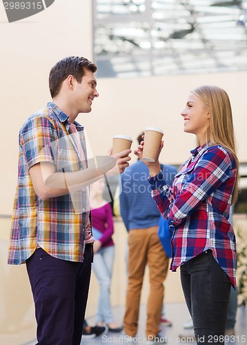 Image of group of smiling students with paper coffee cups