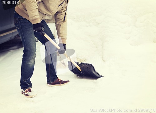 Image of closeup of man shoveling snow from driveway