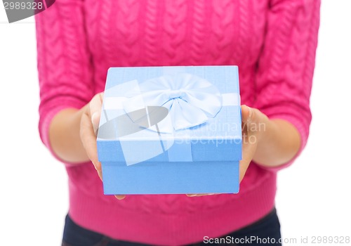 Image of close up of woman in pink sweater holding gift box