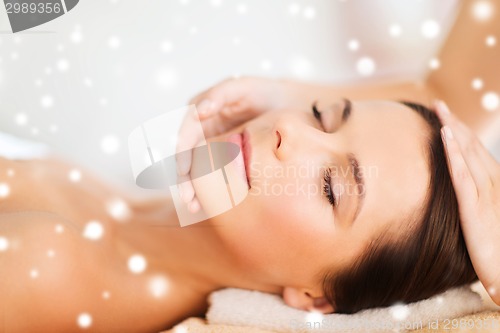 Image of beautiful woman getting face or head massage