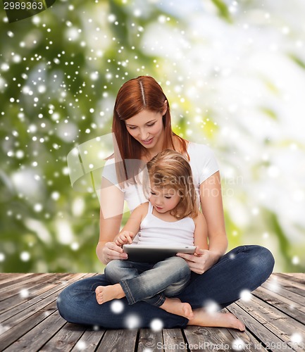 Image of happy mother with little girl and tablet pc