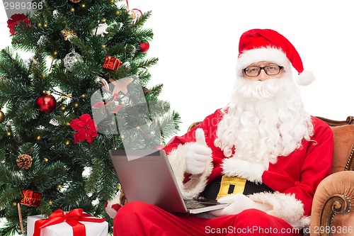 Image of man in costume of santa claus with laptop