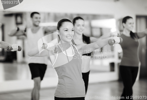 Image of group of smiling people working out with dumbbells