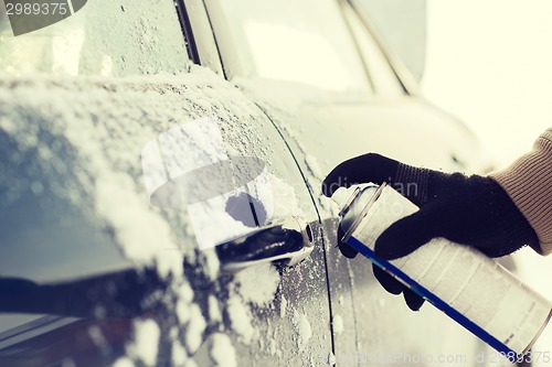 Image of closeup of man hand with lock door de-icer