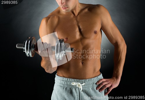 Image of close up of young man with dumbbell