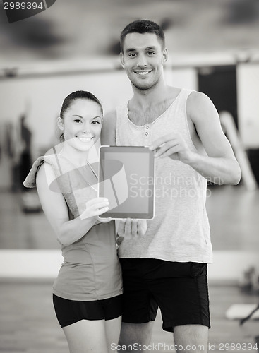 Image of two smiling people showing blank tablet pc screen