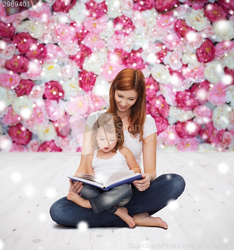 Image of happy mother with little girl and book