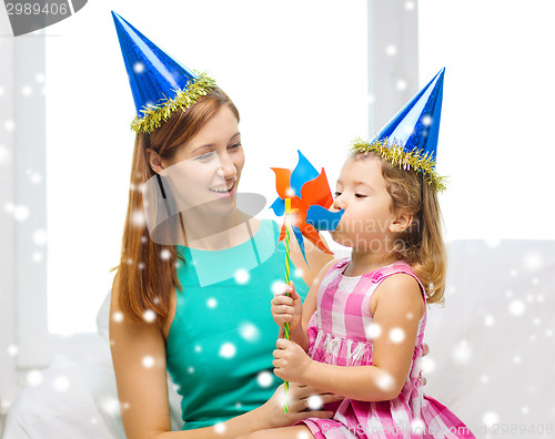 Image of mother and daughter in party hats with pinwheel