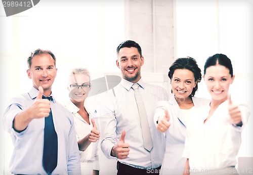 Image of business team showing thumbs up in office