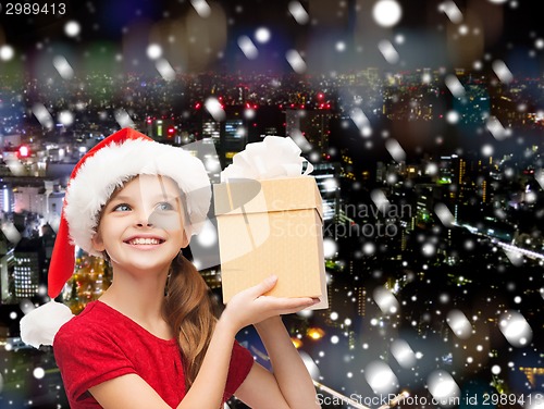 Image of smiling girl in santa helper hat with gift box