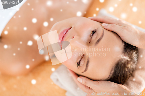 Image of beautiful woman getting face or head massage