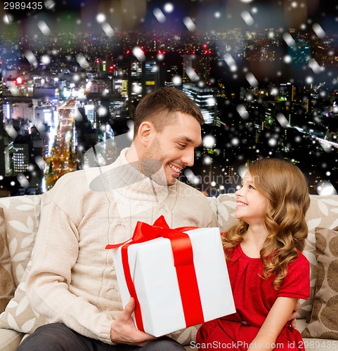 Image of smiling father and daughter with gift box