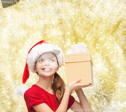 Image of smiling girl in santa helper hat with gift box