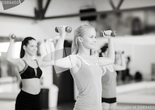 Image of group of smiling women working out with dumbbells