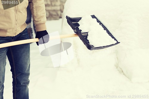 Image of closeup of man shoveling snow from driveway