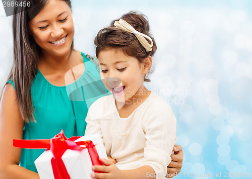 Image of happy mother and little girl with gift box