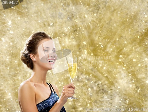 Image of smiling woman holding glass of sparkling wine