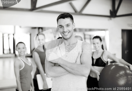Image of smiling man standing in front of the group in gym
