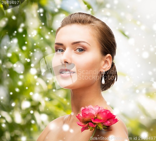Image of woman with diamond earrings, ring and flower