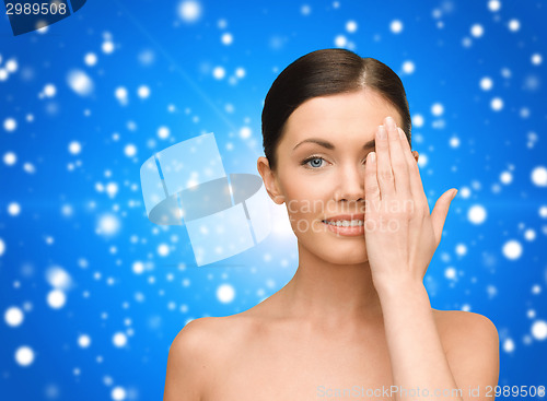 Image of smiling young woman covering face with hand