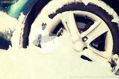 Image of closeup of car wheel stuck in snow