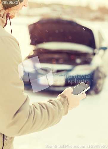 Image of closeup of man with broken car and cell phone