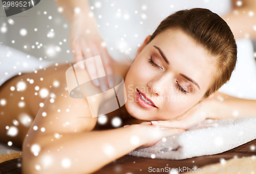 Image of beautiful young woman in spa salon getting massage