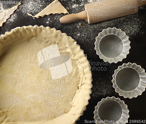 Image of freshly maked dough in a baking tart form 