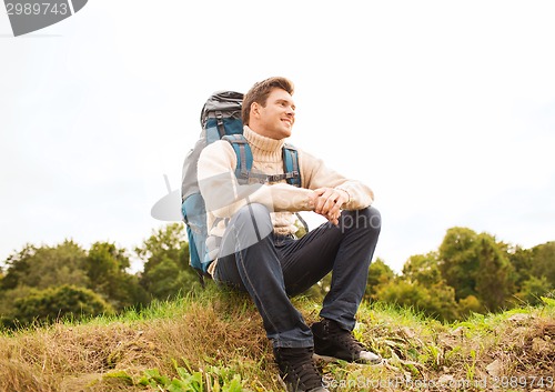 Image of smiling man with backpack hiking