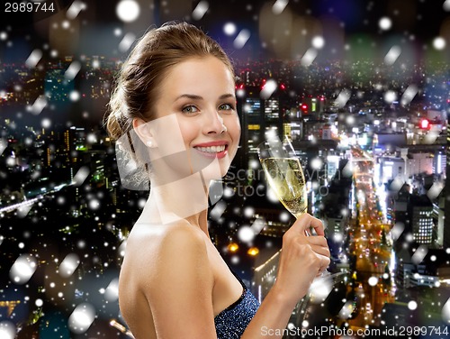 Image of smiling woman holding glass of sparkling wine