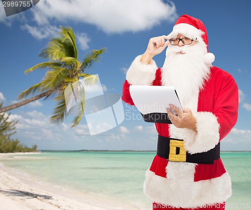 Image of man in costume of santa claus with notepad