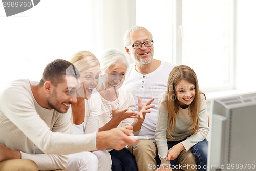 Image of happy family watching tv at home