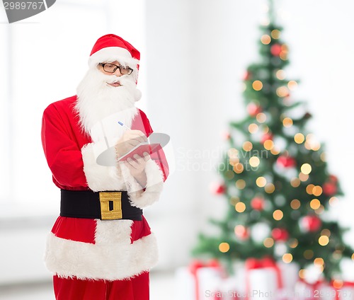 Image of man in costume of santa claus with notepad