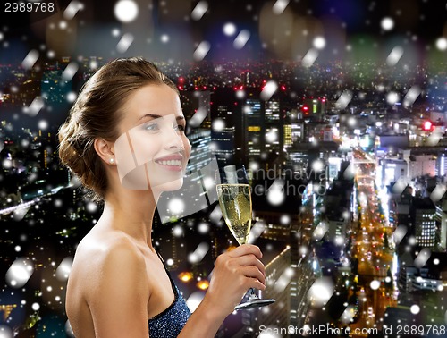 Image of smiling woman holding glass of sparkling wine