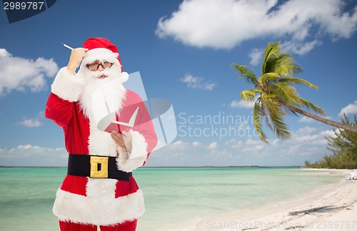 Image of man in costume of santa claus with notepad