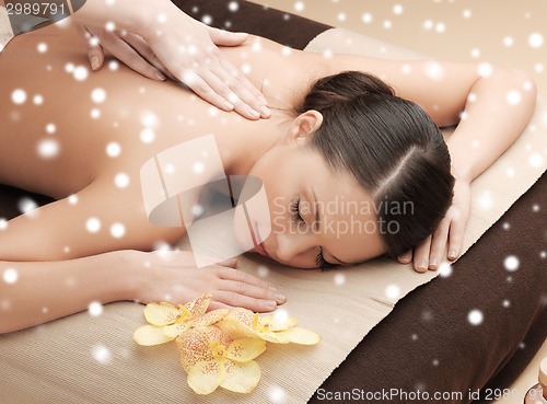 Image of beautiful young woman in spa salon getting massage