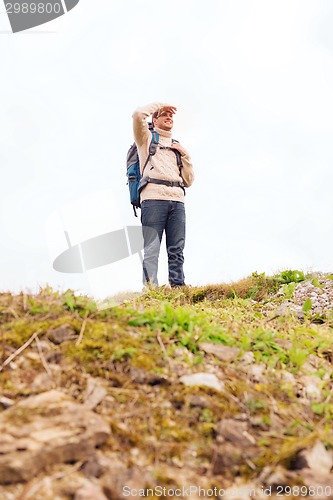 Image of smiling man with backpack hiking