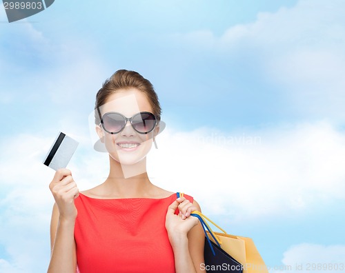 Image of smiling woman with shopping bags and plastic card