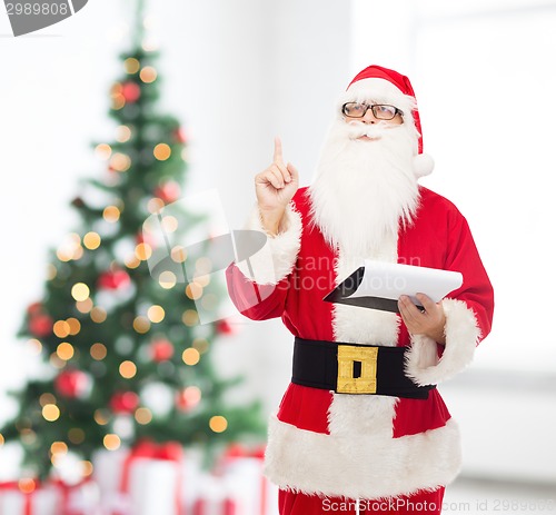 Image of man in costume of santa claus with notepad