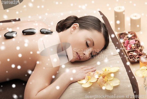 Image of woman in spa salon with hot stones