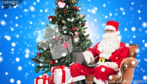 Image of man in costume of santa claus with laptop