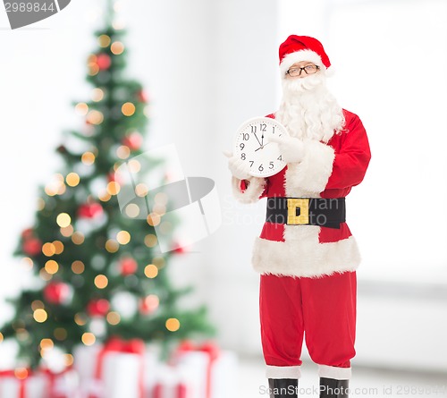 Image of man in costume of santa claus with clock