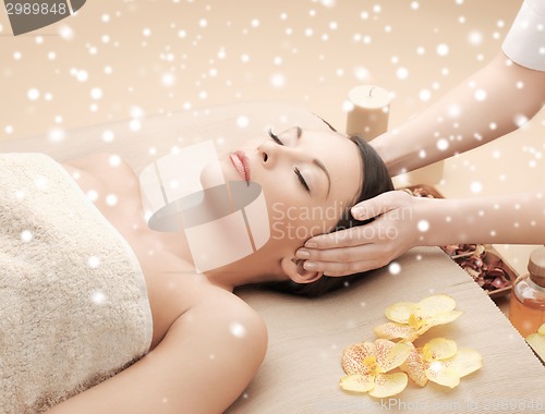 Image of beautiful woman getting face or head massage