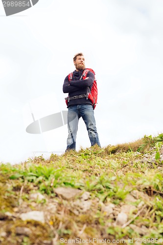 Image of smiling man with backpack hiking