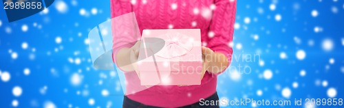 Image of close up of woman in pink sweater holding gift box