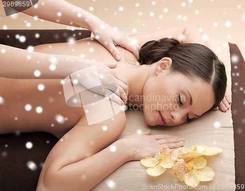 Image of beautiful young woman in spa salon getting massage