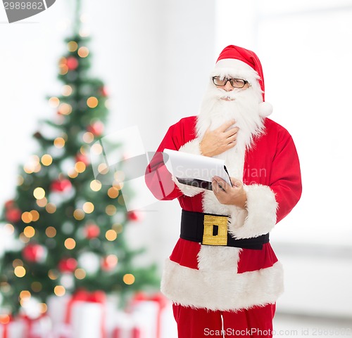 Image of man in costume of santa claus with notepad