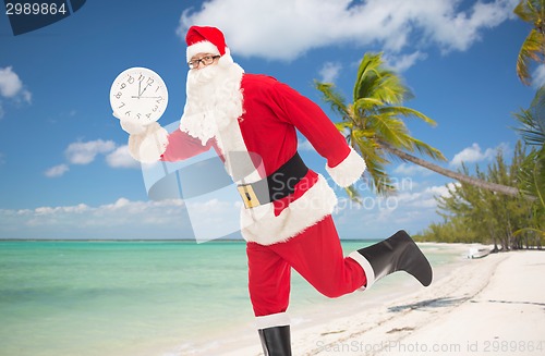 Image of man in costume of santa claus with clock