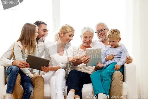 Image of smiling family with tablet pc at home